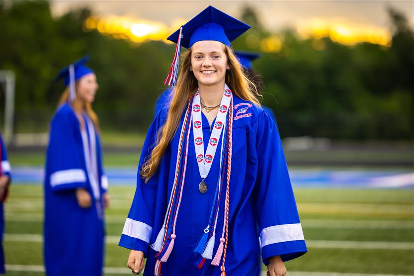 Students in blue robes graduate